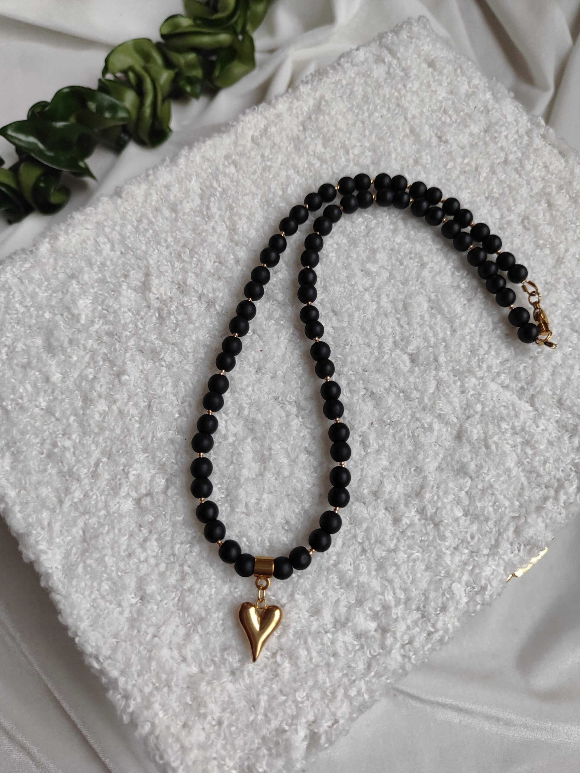 Juodas vėrinys su auksine širdele