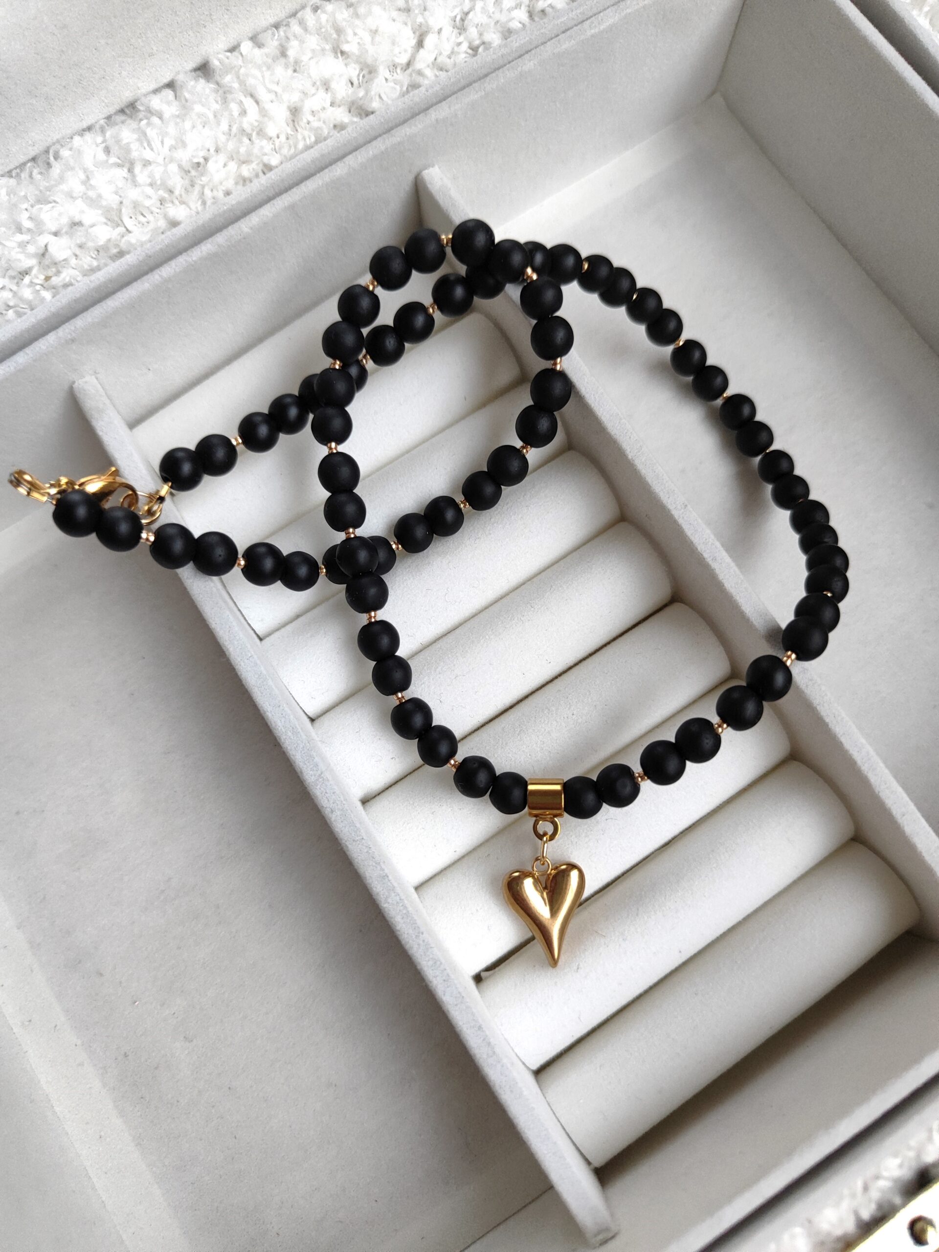 Juodas vėrinys su auksine širdele