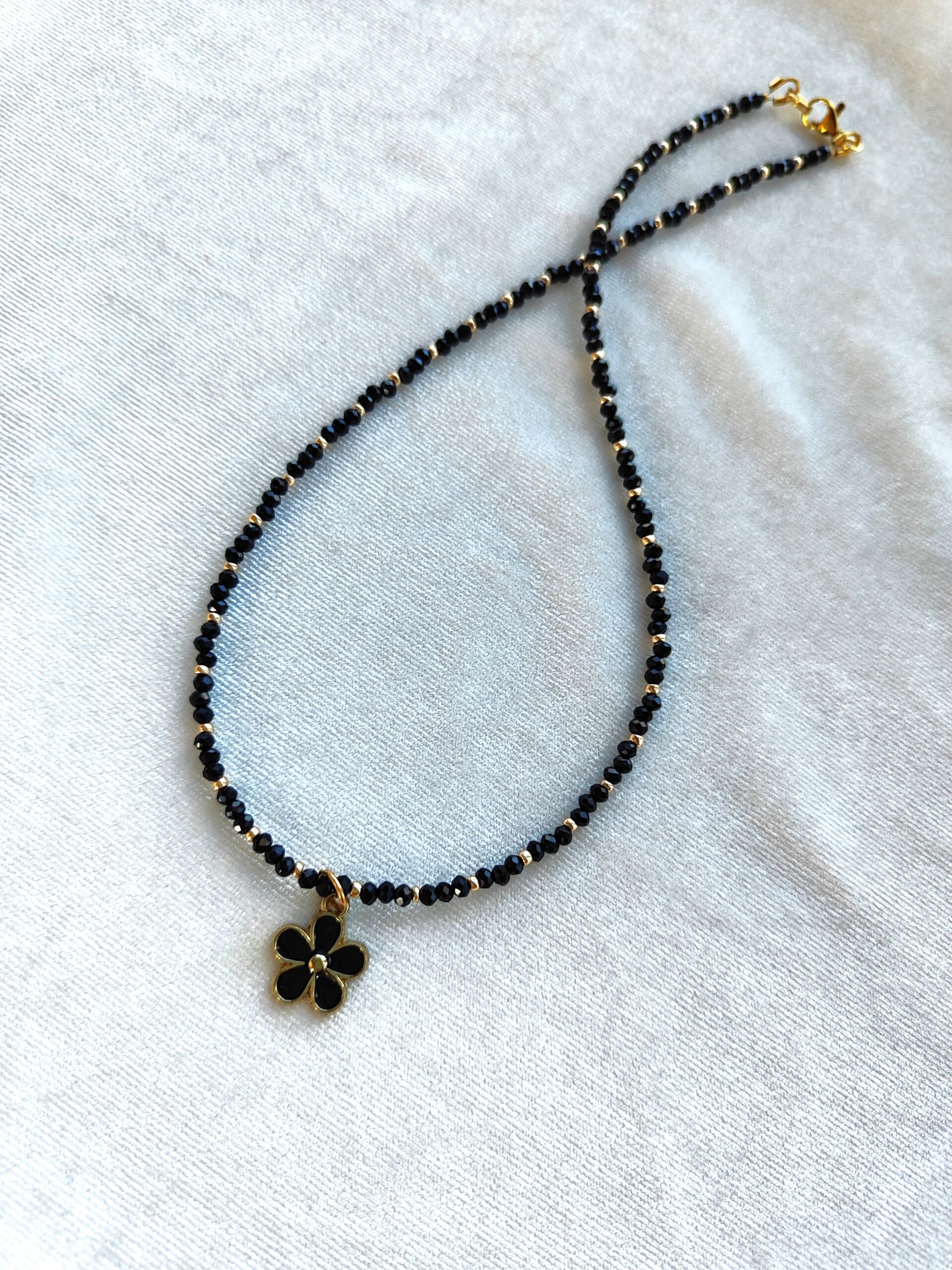 Juodo stiklo vėrinys su gėlės pakabuku