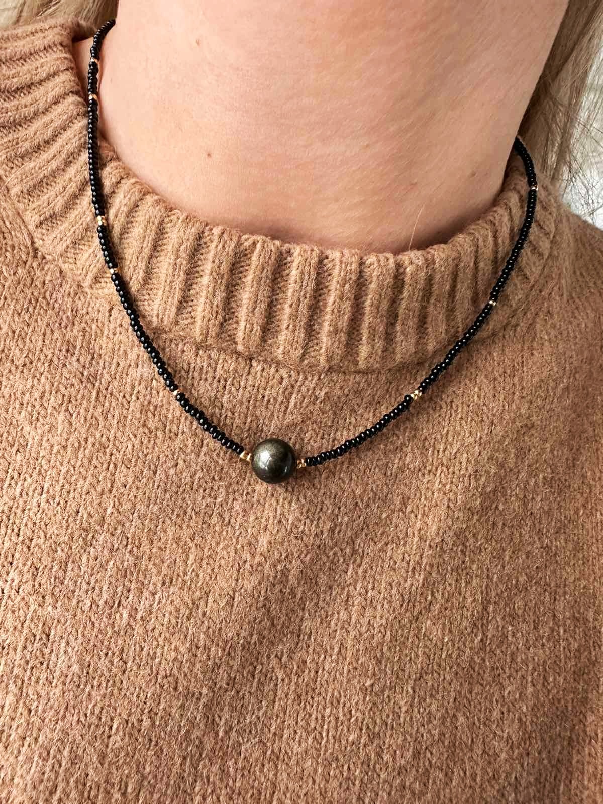 Smulkus juodos spalvos čekiško stiklo vėrinys su auksiniu obsidianu