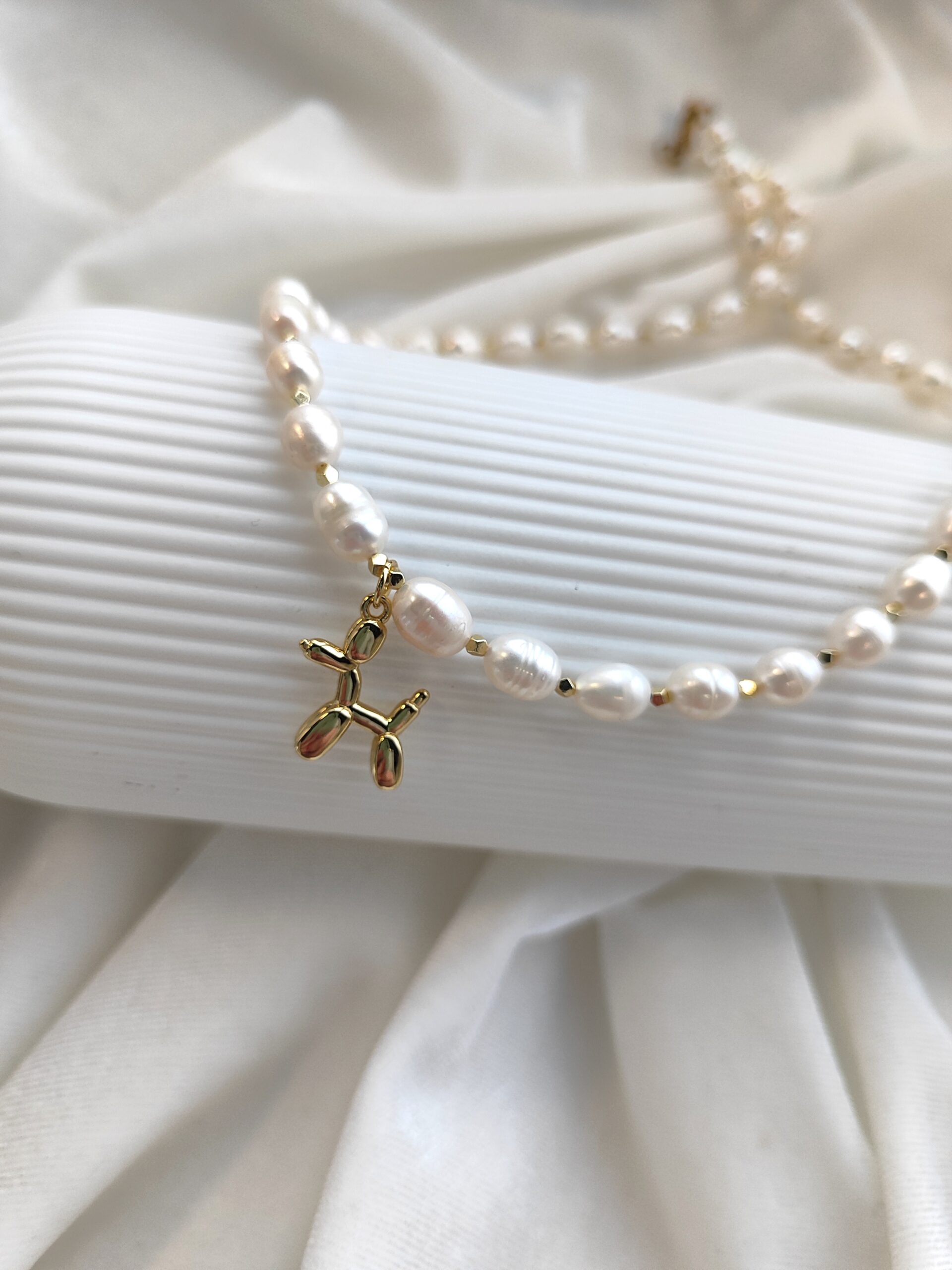 Upinių perlų vėrinys su šuniuko pakabuku