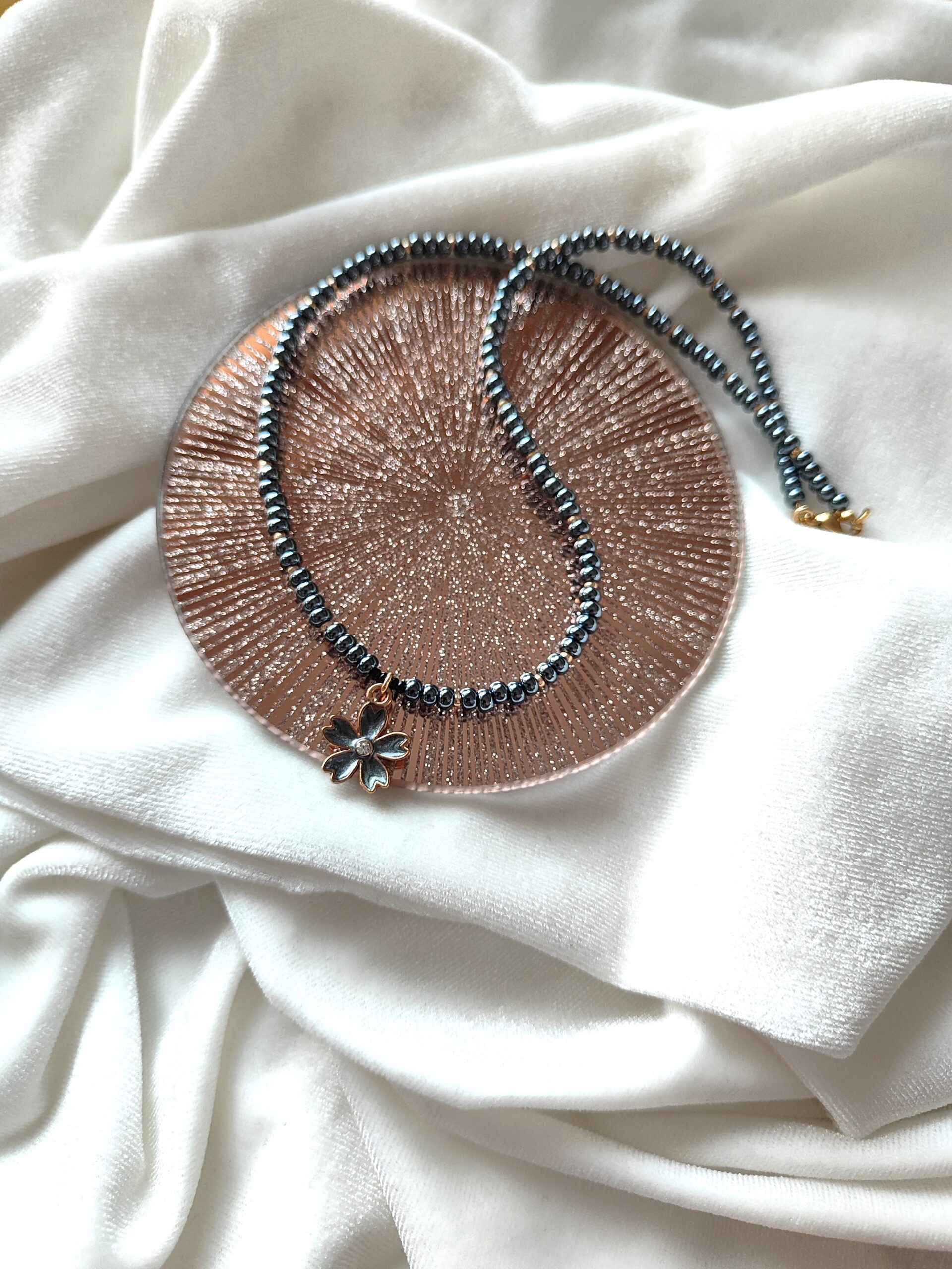 Tamsus stiklo vėrinys su gėlytės pakabuku