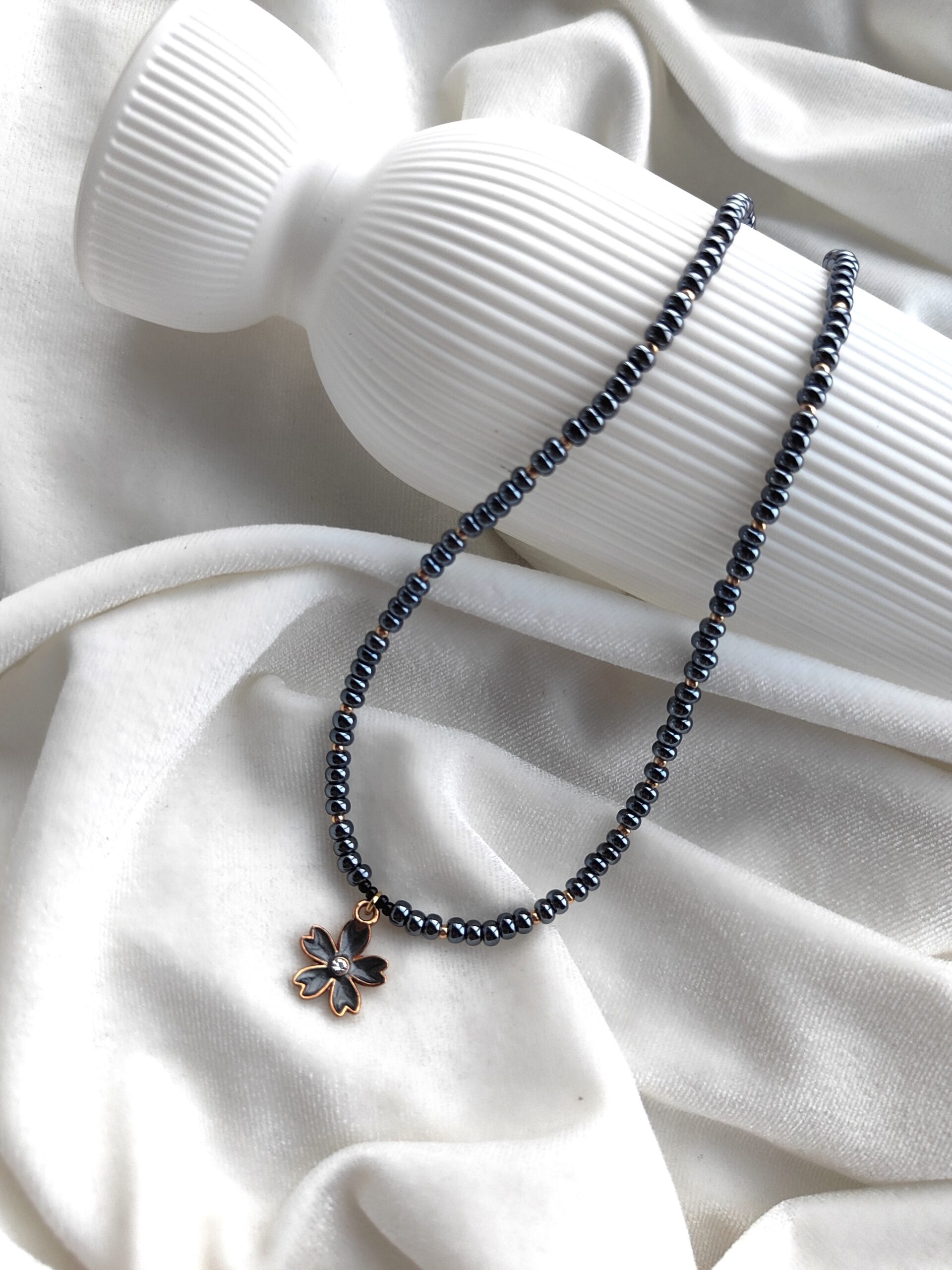 Tamsus stiklo vėrinys su gėlytės pakabuku