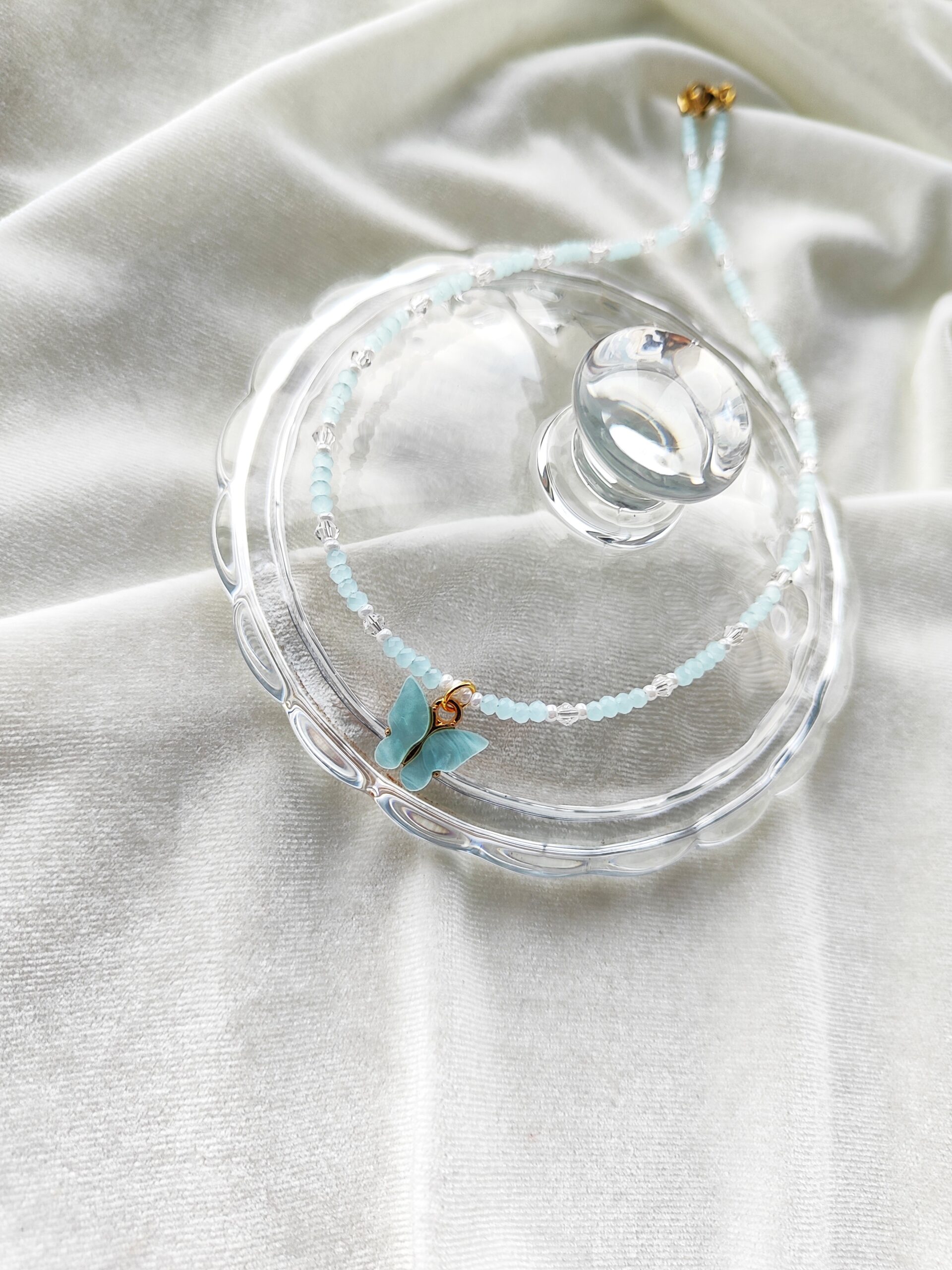 Žydros spalvos vėrinys su drugelio pakabuku