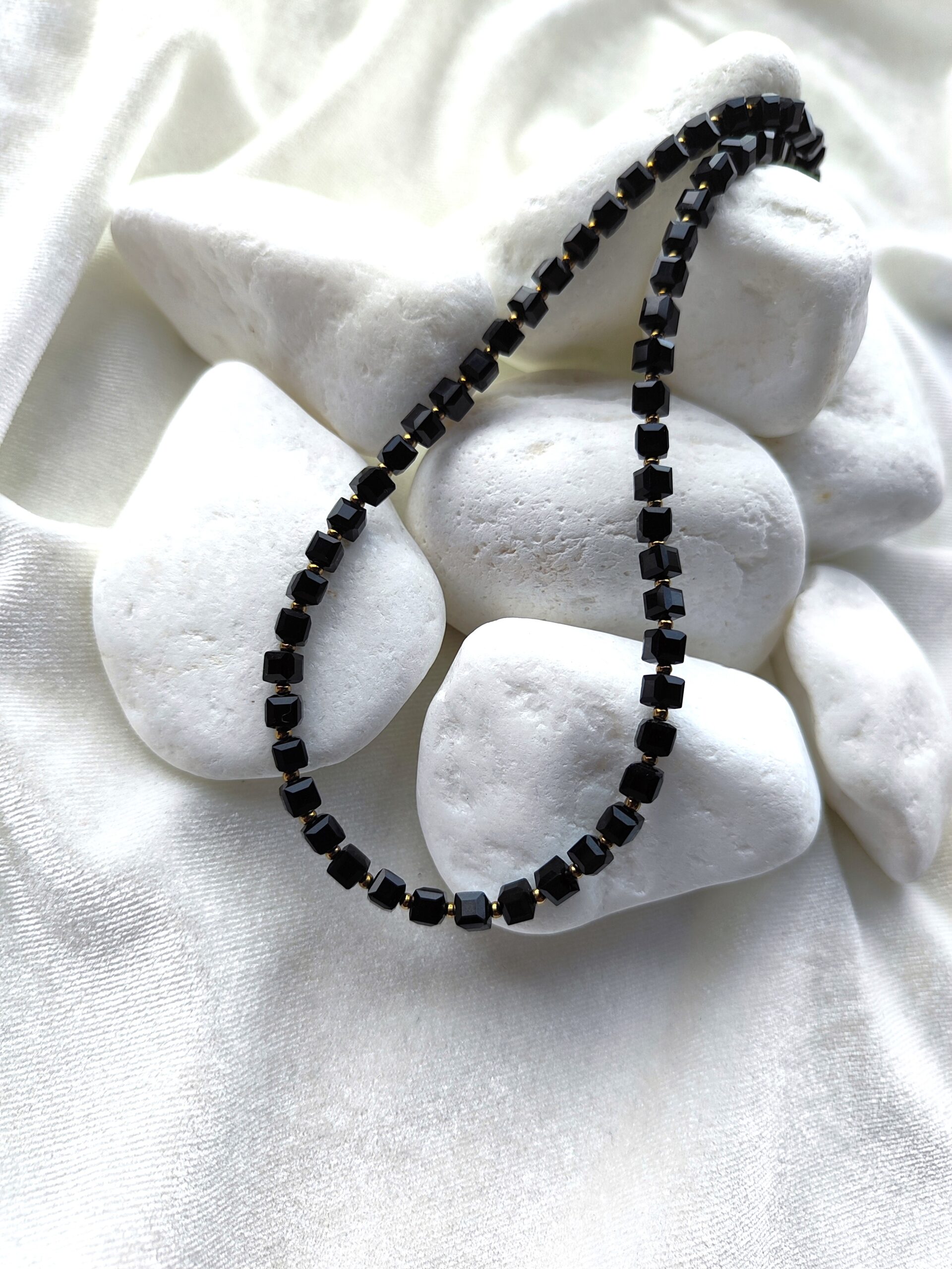 Juodo stiklo kubelių vėrinys